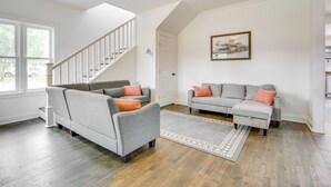 A living room with two grey sofas, a wooden floor, a ceiling fan, and a staircase. - Walk to Winery: Family-friendly Holt Getaway (Holt)