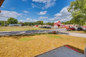 A rural setting with a red building, a paved road, and vehicles parked along the street. - Walk to Winery: Family-friendly Holt Getaway (Holt)