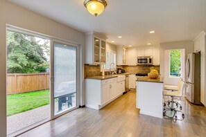 A modern kitchen with white cabinets, a microwave, and a refrigerator.