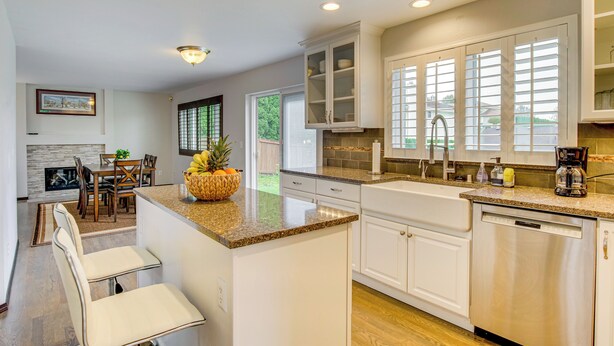 A modern kitchen with white cabinetry, granite countertops, and a central island. - Washington Retreat w/ Yard - Near Seattle! (Marysville)