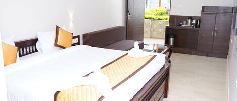 A hotel room with a large bed, a wooden headboard, a bedside table, a nightstand, a wardrobe, and a view of the outside.