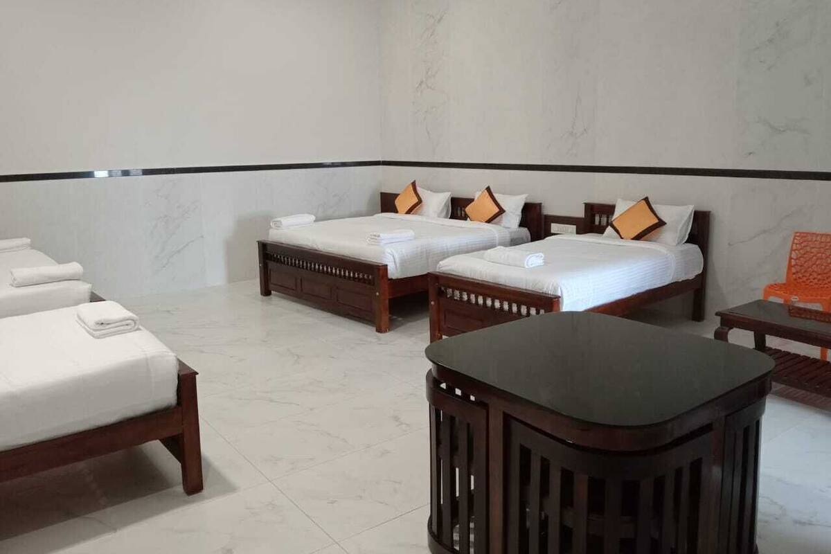 Une chambre d’hôtel avec deux lits, une petite table et une chaise.