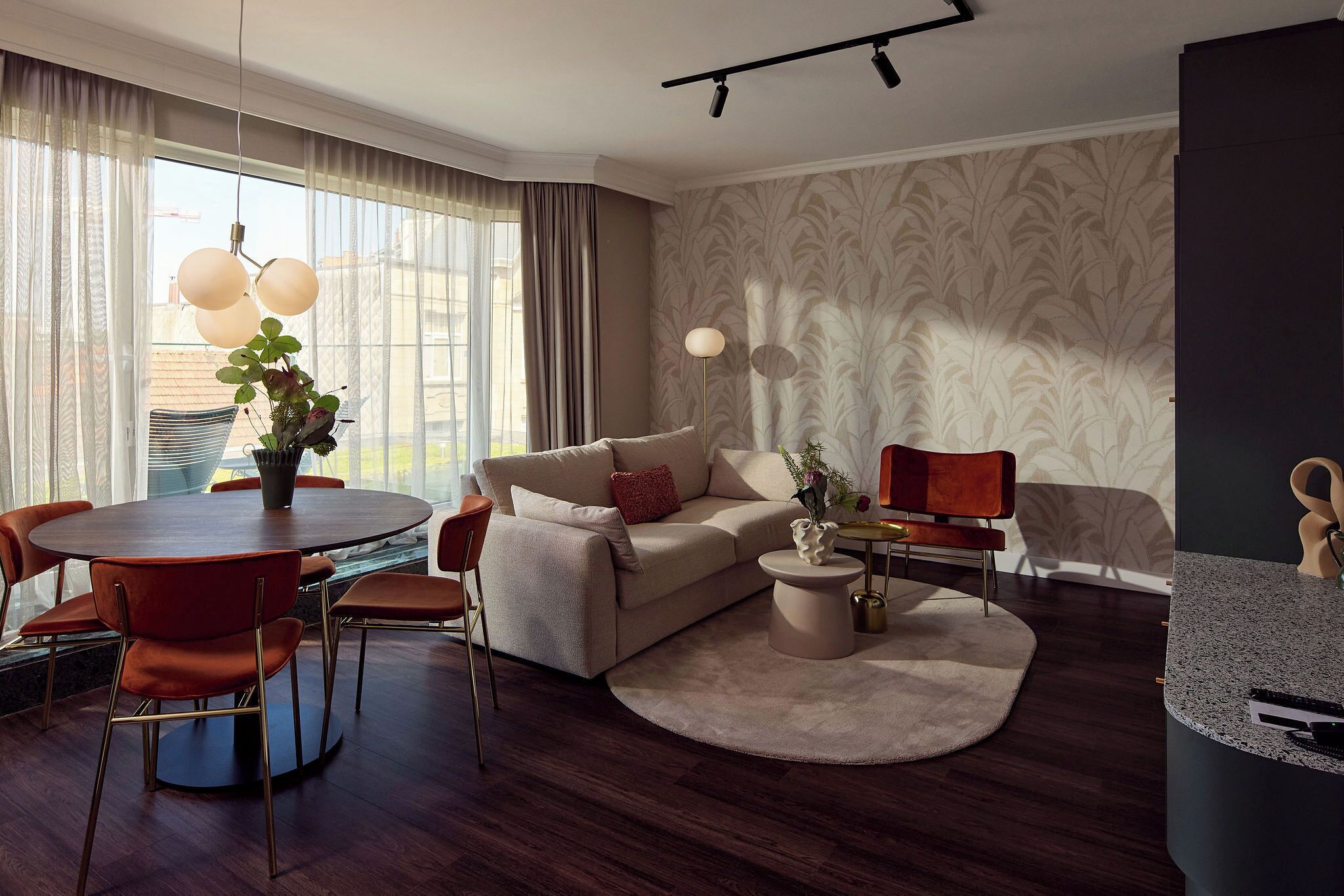 Una sala de estar moderna con una mesa de comedor redonda, un sofá y una mesa auxiliar.