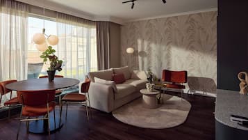 Una sala de estar moderna con una mesa de comedor redonda, un sofá y una mesa auxiliar.