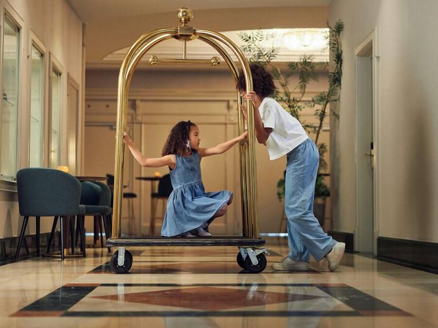 Rebost d'hotel amb una arc decoratiu central, zona de seients amb cadires i un paviment estampat.