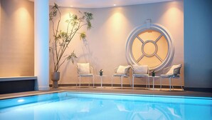 Zona de piscina con pileta transparente, sillas de descanso, una planta en maceta y un elemento decorativo en la pared.