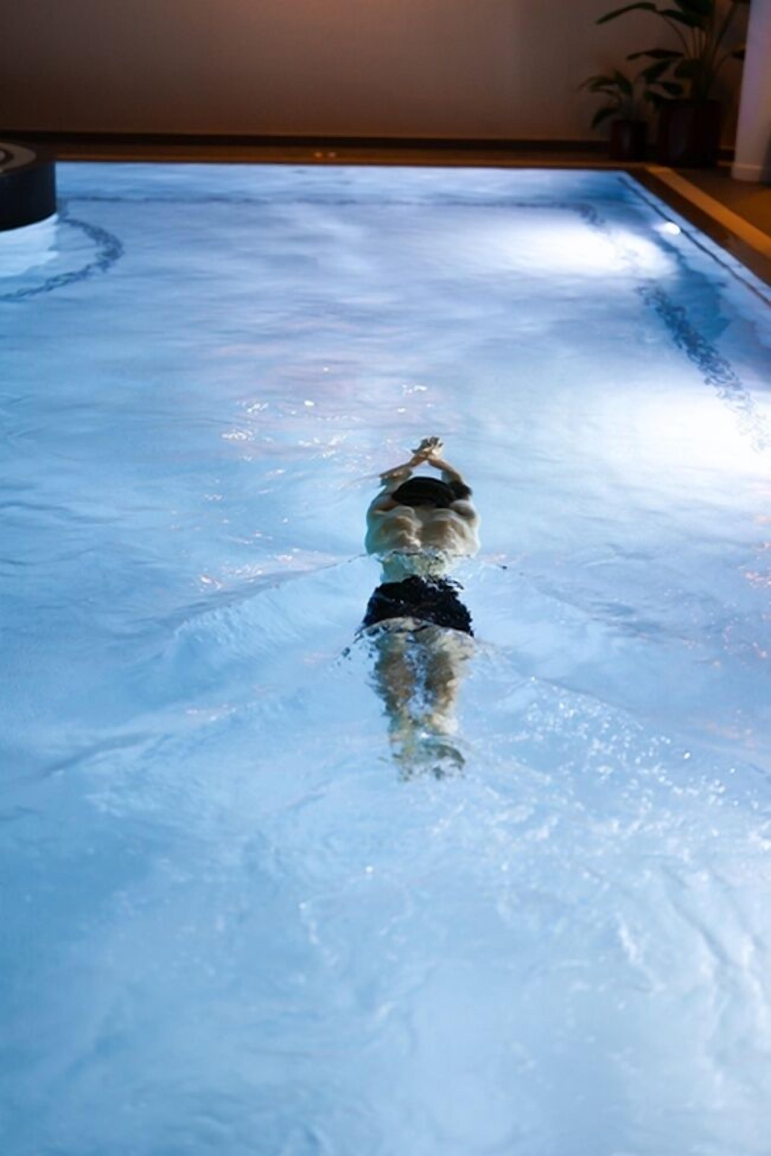 Une personne qui nage dans une piscine.