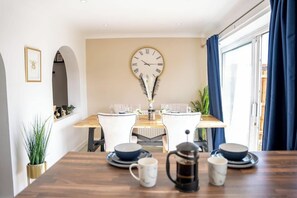 Enjoy meals in this stylish dining area with a large table for two, a wall clock, and beautiful views.