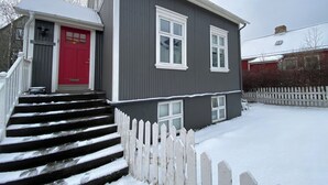 A two-story house with a red door and white-framed windows. - Day Dream Vesturgata 5a (Reykjavik)