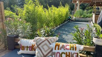 Un jardin avec un banc en bois, des plantes en pot et une vue sur les montagnes.