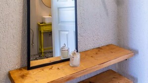 A bathroom with a wooden shelf, a mirror, and a hanging clothes rack. - Skopelos Seaview Suite - Hebe Summer Nest (Stafylos)