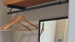 Ein Zimmer mit einem Holzboden, einem Spiegel und einer Tür.