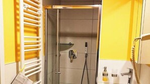 Une petite salle de bain avec une douche, des toilettes et un lavabo.