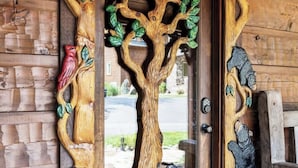 Una puerta de madera con intrincados grabados de un árbol, un pájaro y un oso.