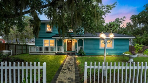 A two-story house with a porch, a white picket fence, and a pathway leading to the front door. - Relaxing Home Near St. Augustine Attractions 4 Bedroom Residence (St. Augustine)