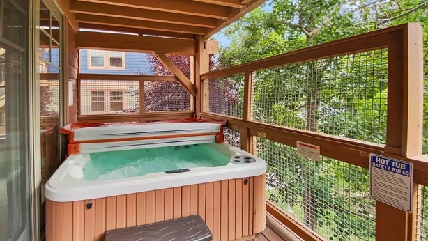 A hot tub area with a wooden deck and a safety sign.