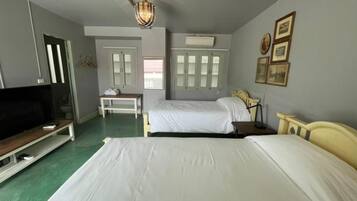 Een hotelkamer met twee bedden, een televisie, een bureau en een kledingkast.