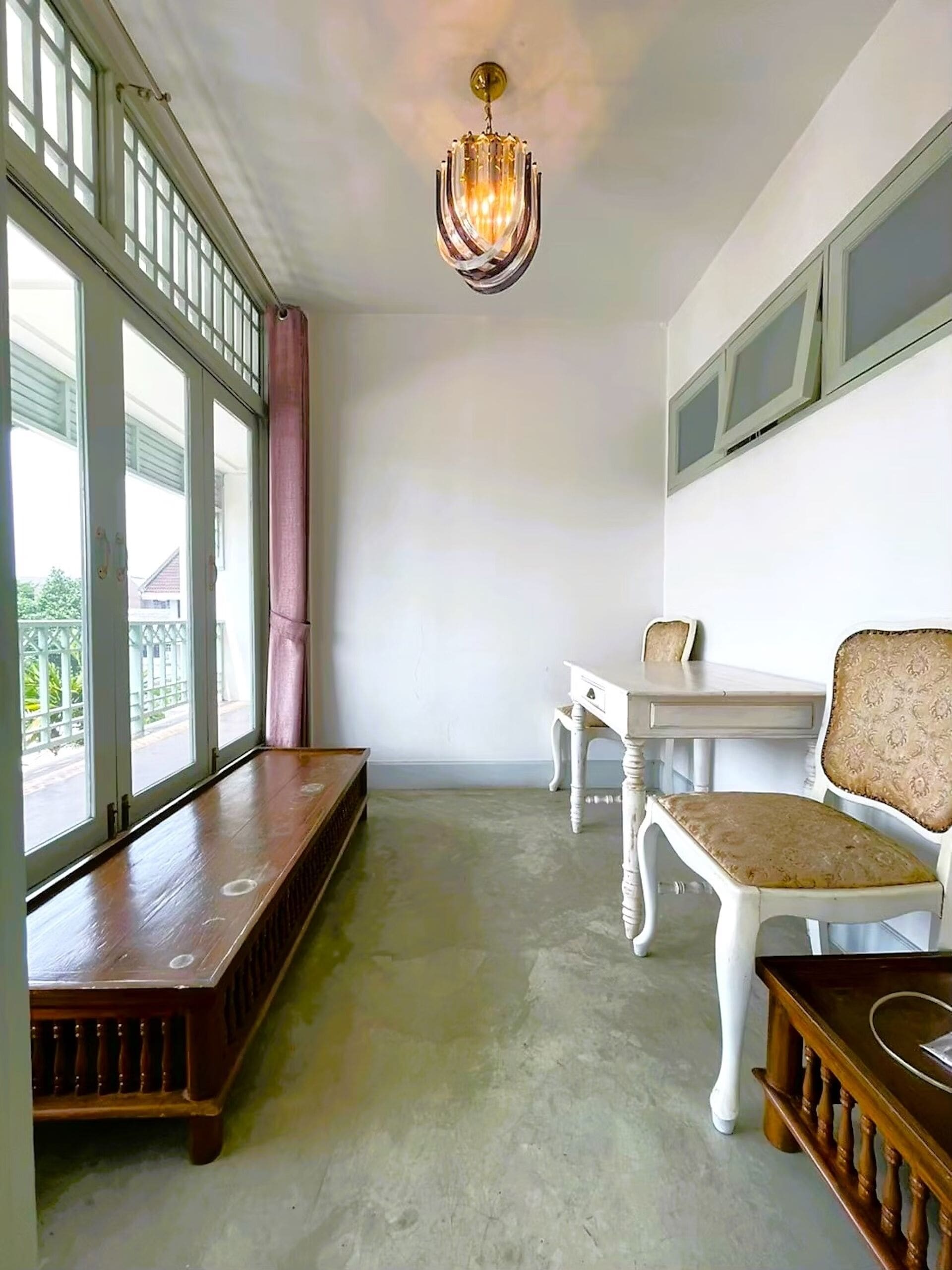 Una habitación con un banco, una mesa y sillas.
