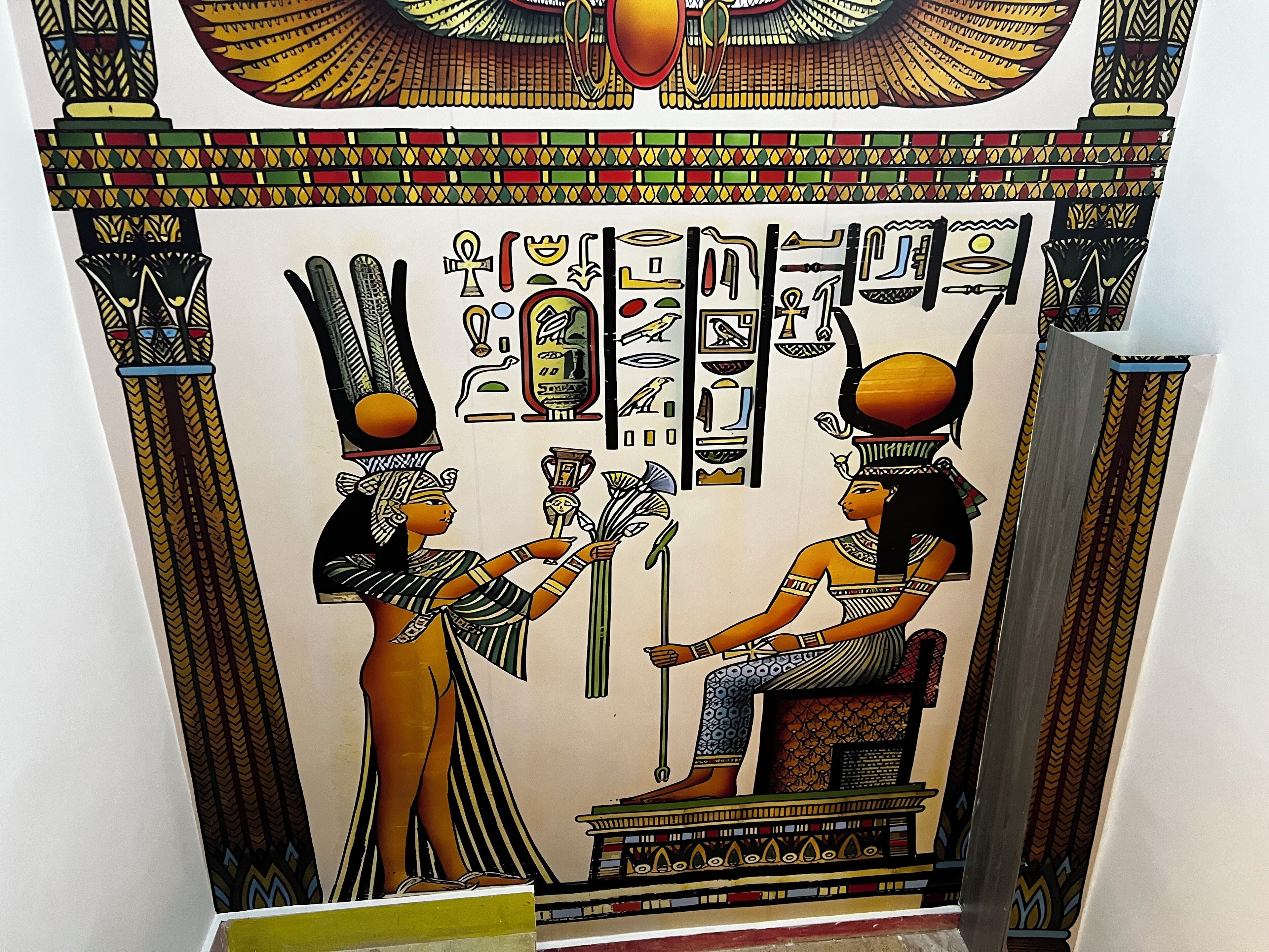 A wall with ancient Egyptian hieroglyphs and figures.