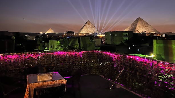 A view of the pyramids at sunset with a crowd in the foreground. - Jana pyramids view inn (Giza)