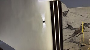 A ceiling with a light fixture and a marble wall. - Jana pyramids view inn (Giza)