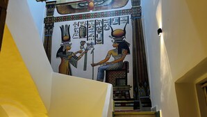 A staircase with a mural of ancient Egyptian figures and hieroglyphs. - Jana pyramids view inn (Giza)