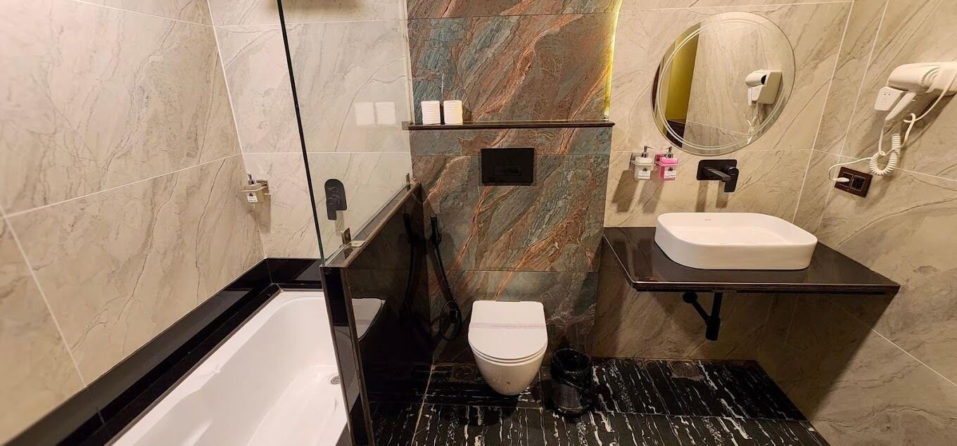 Un baño con bañera, inodoro, tocador y espejo.