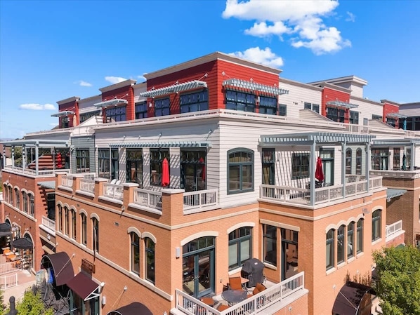 A multi-story hotel with balconies, large windows, and a brick facade.