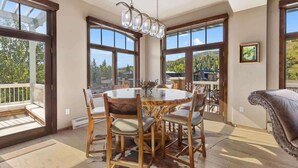 A dining area with a round table, chairs, and a chandelier.