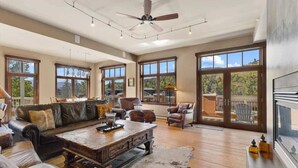 A spacious living room with a large sofa, a coffee table, and a fireplace.