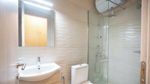 A modern bathroom with a glass-enclosed shower, a white sink, and a toilet. - Monastiraki metro st studio for 2 persons by MPS (Athina)