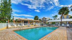 A swimming pool with a tiled deck, lounge chairs, and a covered seating area. - 8 Mi to Beach w/ Pool Access: Englewood Condo! (Englewood)
