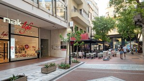 Une zone commerciale comprenant un magasin appelé « nak light » et un restaurant doté d’une terrasse.