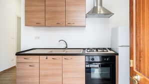 Une cuisine moderne avec des meubles en bois, une hotte de cuisine en acier inoxydable, un évier, une cuisinière et un four.