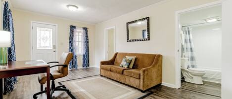 A living room with a brown sofa, a wooden coffee table, and a patterned rug.