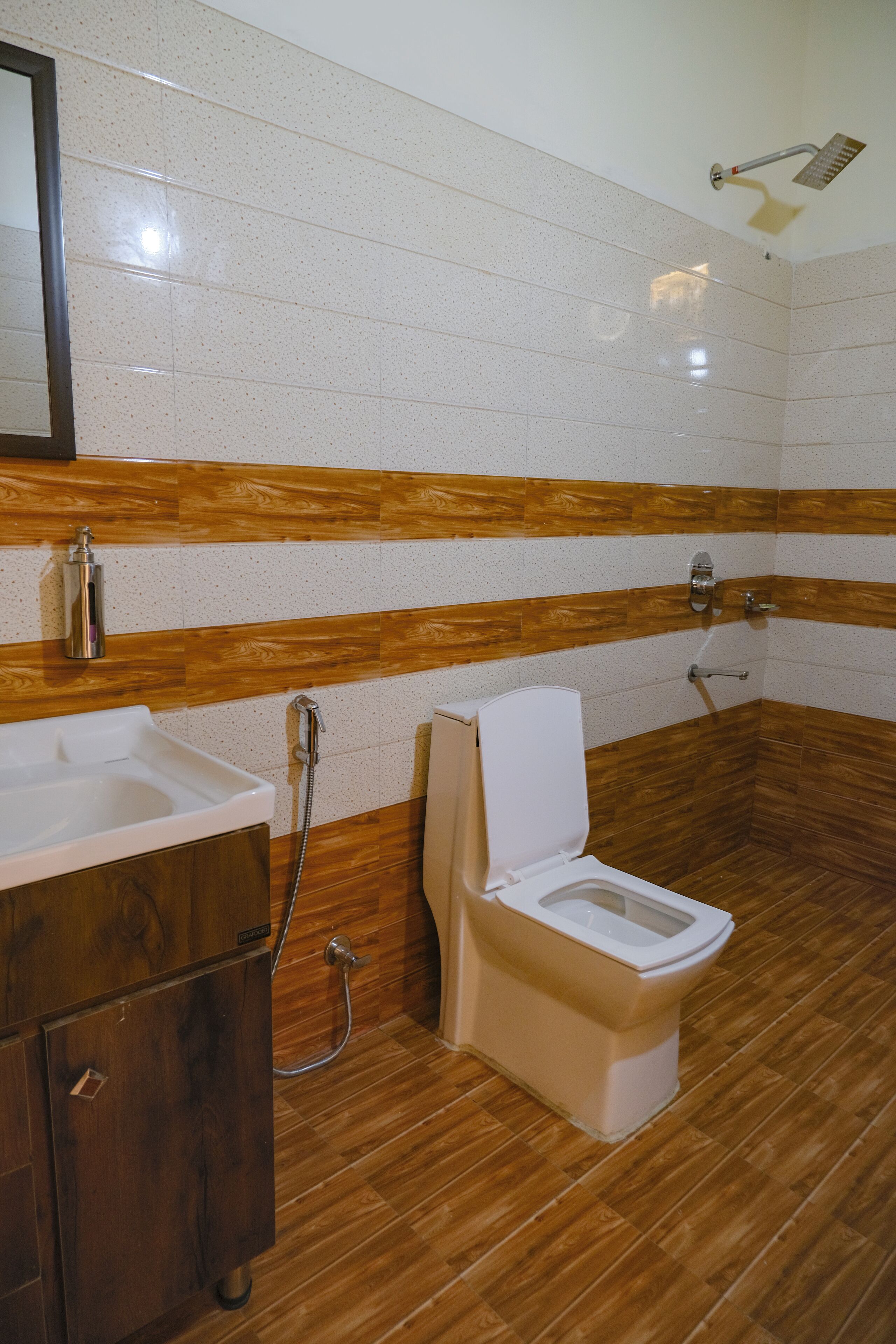 A bathroom with a wooden vanity, a toilet, and a shower.
