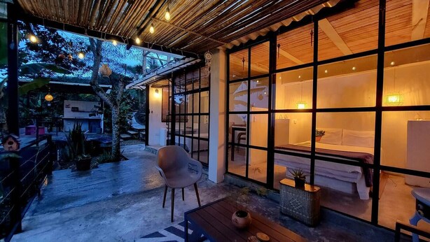An outdoor seating area with a wooden table and chairs, a bench, and a potted plant. - Alban, Longo Mai - Cabaña Aqua - Via Namay Alto (Alban)