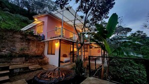 A two-story house with a balcony, surrounded by lush greenery. - Alban, Longo Mai - Cabaña Aqua - Via Namay Alto (Alban)