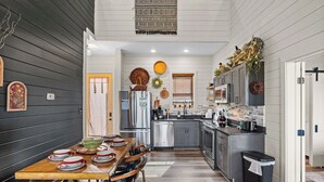 A modern kitchen with dark wooden walls, a central island, and stainless steel appliances.