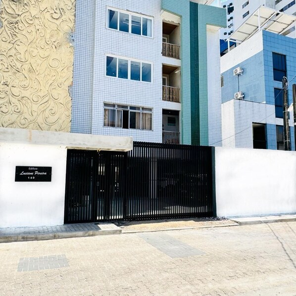 A building with a white facade, a black gate, and a sign reading "Edifício Luciana Pereira 140". - EDF. LUCIANE PEREIRA (Recife)