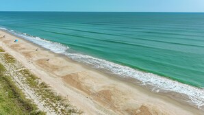 Une plage à l’eau turquoise et limpide, bordée d’un rivage sablonneux.