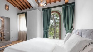 Un dormitorio con una cama grande, techo de madera y ventana con cortinas verdes.