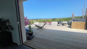 A balcony with a view of the sea, a hammock, and outdoor furniture. - HOUSE WITH INTERIOR SWIMMING POOL WITH SEA VIEW, mini golf course (plouarzel)