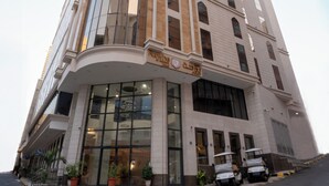Ein Hotel mit modernem Design, das eine geschwungene Glasfassade und einen markanten Eingang mit Vordach aufweist.