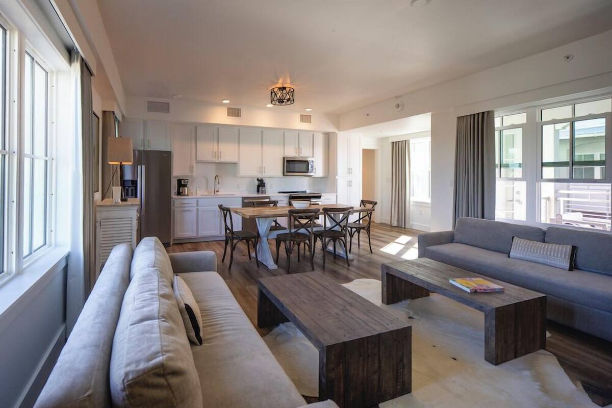 Een moderne woonkamer met een bank, salontafel en een eethoek.