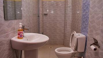 Een douche, handdoeken, zeep, shampoo