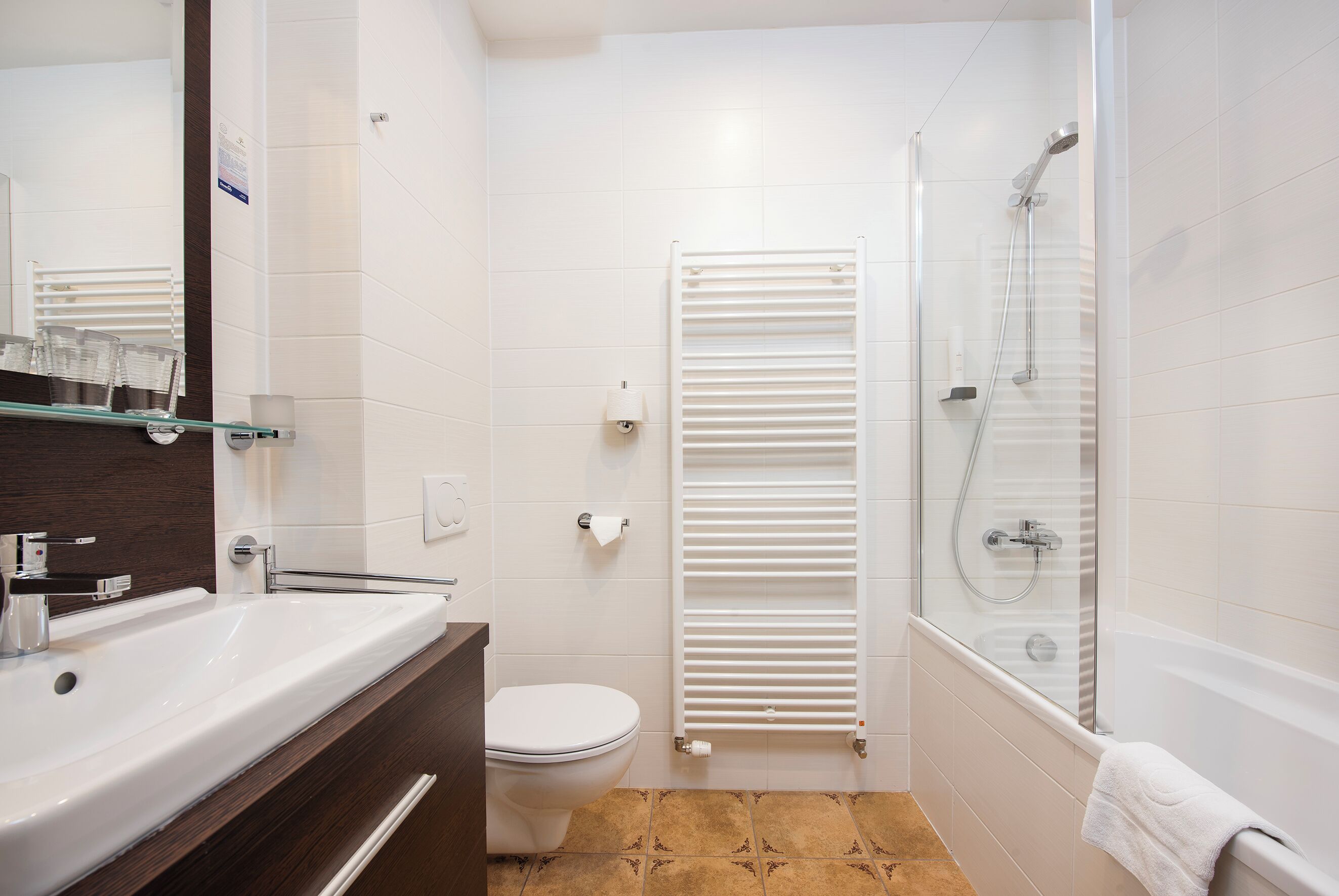 Une salle de bain moderne avec un lavabo, des toilettes et une douche, le tout de couleur blanche.