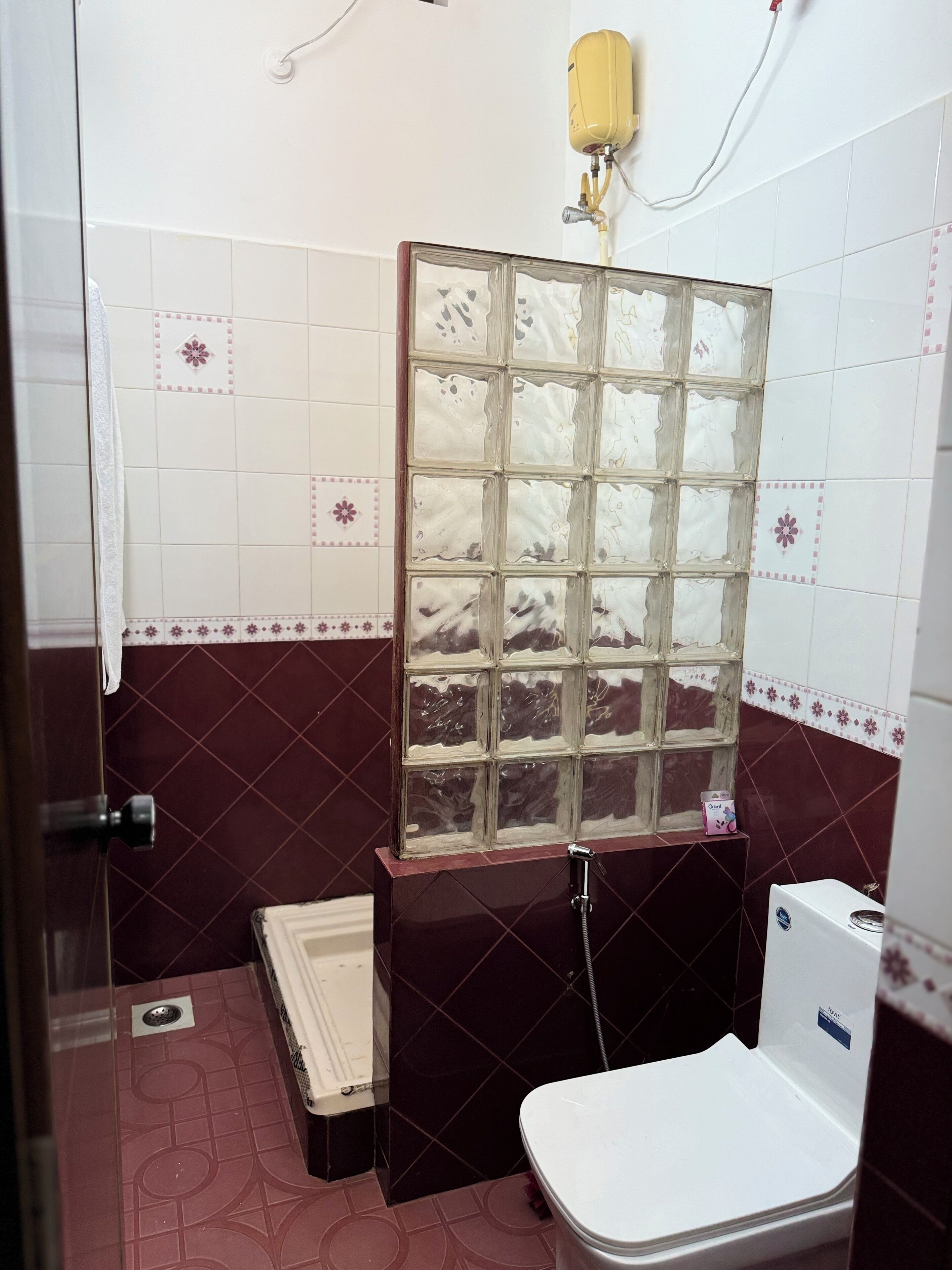 Uma casa de banho pequena com sanita, chuveiro e divisória de vidro.