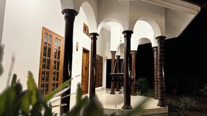 A courtyard with columns, wooden doors, and a tiled floor. - Coconut Creek Homestay (Kottayam)
