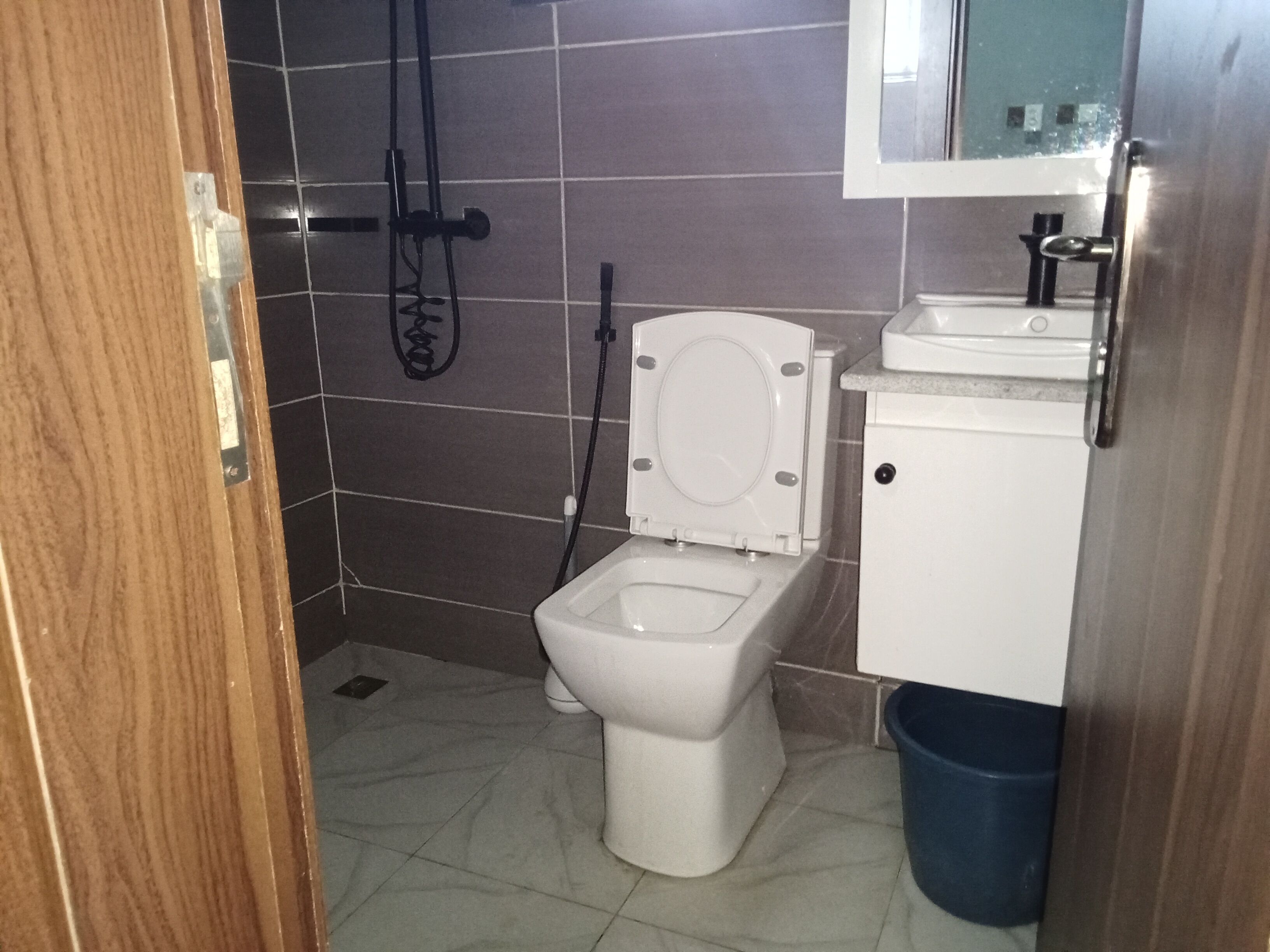 Un baño pequeño con inodoro, lavabo y ducha.